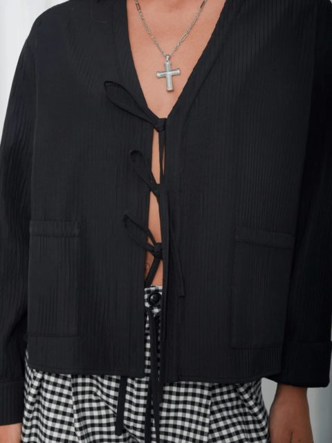 A fluid black blouse by @arpyes , fastened with delicate ribbons.
Soft structure, undone allure.
Tailored ease with a rebellious whisper.